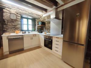 Caboalles de AbajoLa Escondida的厨房配有白色橱柜和不锈钢冰箱