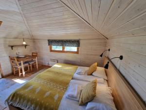 尤卡斯耶尔维Reindeer Lodge的一张大床,位于带桌子的木制房间内