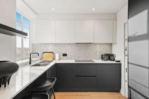 伦敦Luxury Kensington Flat with Terrace and AC的厨房配有黑白橱柜和水槽