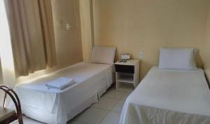 博阿维斯塔Barrudada Palace Hotel-Boa Vista的一间小型客房,配有两张床和 夜 ⁇ 