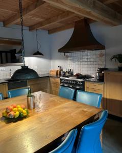 奥斯楚特Casa Fuori的厨房配有木桌,上面放着一碗水果