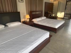 NikaweratiyaMagalle Wewa Villa的配有两张床的酒店客房中的两张床