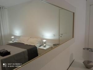 卡斯特拉纳格罗泰Valevi 111的镜子反射着白色房间的床