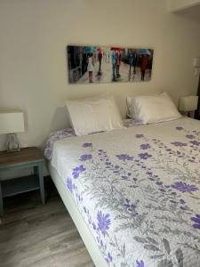拉马巴耶Petite Plaisance Appartements的卧室配有一张床,墙上挂有绘画作品