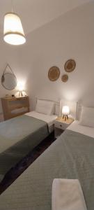 利普西岛Orizodas的一间卧室配有两张床、两个灯和两张桌子