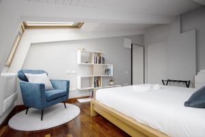 米兰Double Luxury Exclusive Suite-Duomo in 12 Minutes的一间卧室配有一张床和一张蓝色椅子