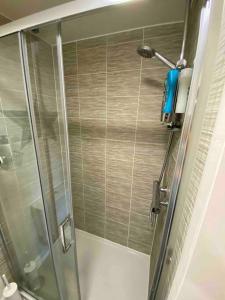 彼得伯勒3 bedroom house - Hampton Water的带淋浴的浴室,带玻璃门