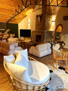 ÇivrilÇatı Katı Bungalow & Dome的客厅配有白色家具和石制壁炉