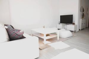 卢森堡Lovely Modern 1 BR apartment的白色的客厅配有白色桌子和电视。