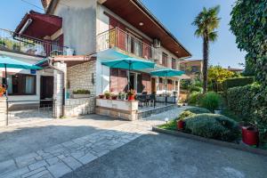 奥帕提亚Apartment Mediteraneo的房屋设有带蓝伞的庭院