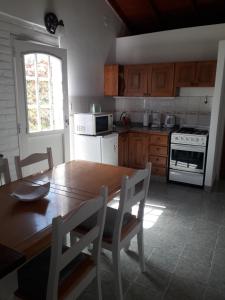 玛德琳港Los Choiques Madryn的厨房配有木桌和桌椅