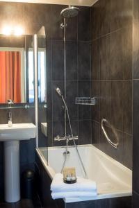 巴黎维多利亚沙特莱酒店的带淋浴、浴缸和盥洗盆的浴室