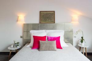 巴黎维多利亚沙特莱酒店的一间卧室配有一张带两个粉红色枕头的床