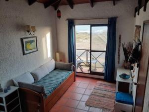 拉帕洛马Apto frente al mar en La paloma的带沙发和大窗户的客厅