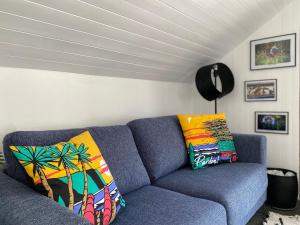 布里昂松La Kaz montagne的客厅里配有带色彩缤纷枕头的蓝色沙发