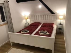 穆尔海姆Ferienhaus im Städtle的一张带红色床单的白色床和两个枕头