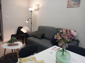 奥伦塞PISO BENITO的客厅配有沙发和花瓶(桌子上)
