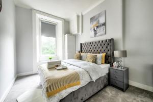 格拉斯哥Two Bed Stylish Apartment in Heart of West End的一间卧室设有一张大床和一个窗户。