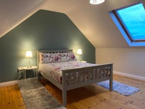 BallingurteenJoe's Place, Central Location West Cork near Clonakilty的一间卧室配有一张床、两盏灯和一个窗户。