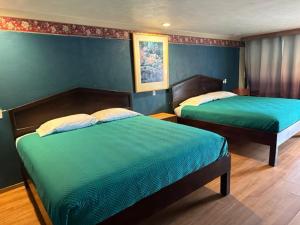 普罗沃普罗沃套房汽车旅馆的卧室设有两张床铺和蓝色的墙壁