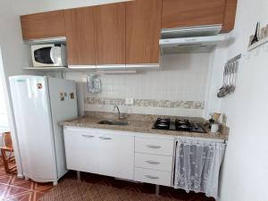 大普拉亚Solar Canto do Forte的厨房配有白色冰箱和水槽