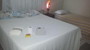 纳塔尔Pousada Hostel Villa Bella Mar的一张带白色床单的床和两张带毛巾的床