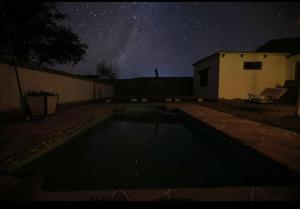 圣佩德罗·德·阿塔卡马Cabañas Voyage Atacama的在一个院子里的游泳池度过一个星空的夜晚