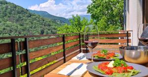 托尔明Moksha Slovenia的一张桌子,上面放着两盘食物和一杯葡萄酒