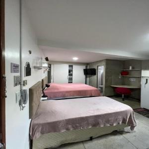 贝伦STUDIO 202 | WIFI 600MB | RESIDENCIAL JC, um lugar para ficar.的一间卧室设有两张床,墙上配有电视。
