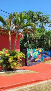 伊瓜苏港Hostel Haus的一座棕榈树和壁画建筑