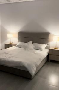 赖斯غرف قاعة وشاليه ومسبح ماز的一间卧室配有一张带两盏灯的大型白色床。