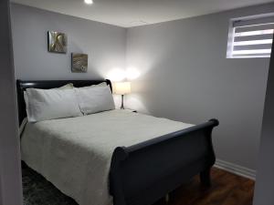 布兰普顿Luxurious 1BR-1BA Apartment Bright Spacious with free parking的一间卧室配有一张带黑色床头板的床和窗户