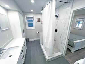 汉密尔顿Limeridge Mall - Open Concept的带淋浴和盥洗盆的白色浴室