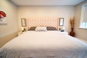 汉密尔顿Hamilton Mountain Plaza - King Bed - Main Floor的卧室配有一张白色大床和两个窗户