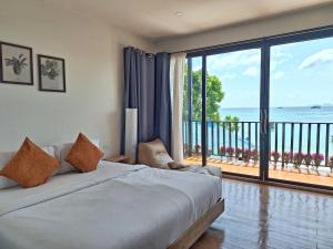 丽贝岛Lipe Sunrise Beach House的一间卧室设有一张床,享有海景