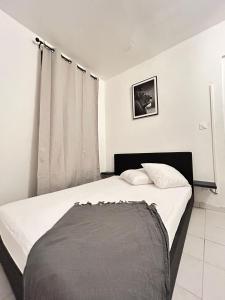 法兰西堡Un Souffle de Vacances的一间卧室配有一张带白色床单的床和一扇窗户。