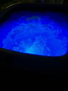 法兰西堡Un Souffle de Vacances的深色房间里充满水的蓝色浴缸