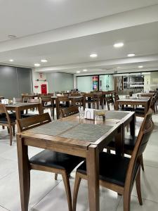 皮拉西卡巴Asa Hotel的用餐室配有木桌和椅子