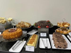 皮拉西卡巴Asa Hotel的一张桌子,上面摆放着各种蛋糕和糕点