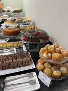 皮拉西卡巴Asa Hotel的一张桌子,上面放着许多不同类型的蛋糕和糕点