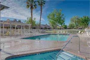 棕榈荒漠Luxurious fairway condo resort country club的一个带围栏和棕榈树的游泳池