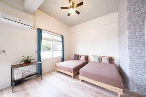 宫古岛Panari的一间卧室设有两张床和砖墙