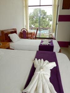 马尔多纳多港Chimicuas House的酒店客房设有三张床和窗户。