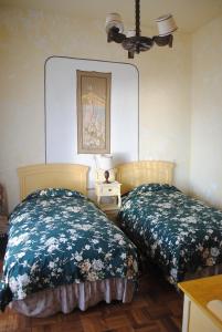 科帕卡巴纳Hostal La Chacarilla的一间卧室配有两张床和一张带台灯的桌子