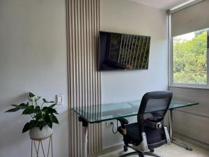 佛罗里达布兰卡Moderna y confortable habitación的一个带玻璃桌和椅子的办公室