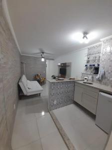 圣洛伦索Apartamento Aconchegante的一个带水槽和椅子的大型白色厨房