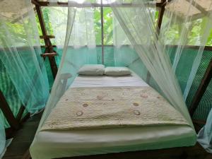 德雷克Rio Agujitas Eco jungle - Island and Corcovado tours的配有蚊帐的客房内的一张床位