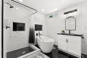 埃斯孔迪多Safari Vines Retreat的白色的浴室设有浴缸和水槽。