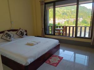 NongkhiawKhamphan Guesthouse的一间卧室设有一张床和一个大窗户