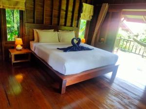 阁遥岛Sabai House Bungalow的一间卧室配有一张带天鹅的床